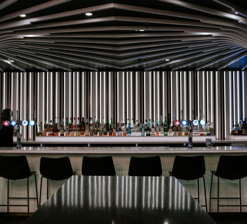 image of the bar with liquor bottles, bar stools and draft beer dispensers.